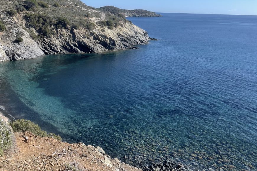 I ciottoli scuri e il mare limpido alla spiaggia Le Tombe